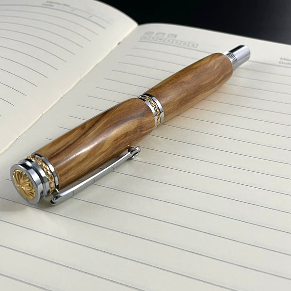 Stylo Roller Luxe Bois Olivier d'Italie avec éléments plaqué Or 24k et Cristal. Personnalisable et livré avec boîte cadeau luxe.