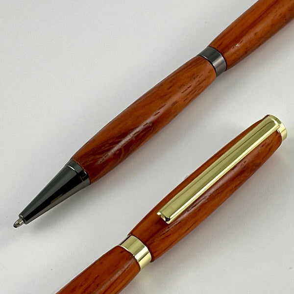 Elements métalliques doré et gris sur stylos bois padouk rouge afrique. Stylos Déclinaisons.
