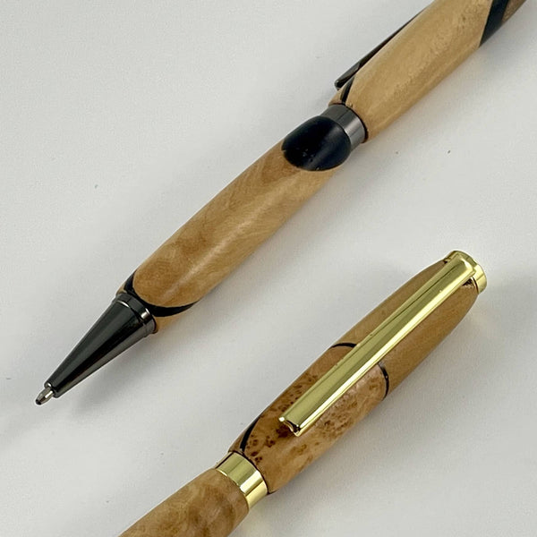 Elements métalliques doré et gris sur stylos bois précieux upcyclés et résine epoxy noire. Stylos Déclinaisons